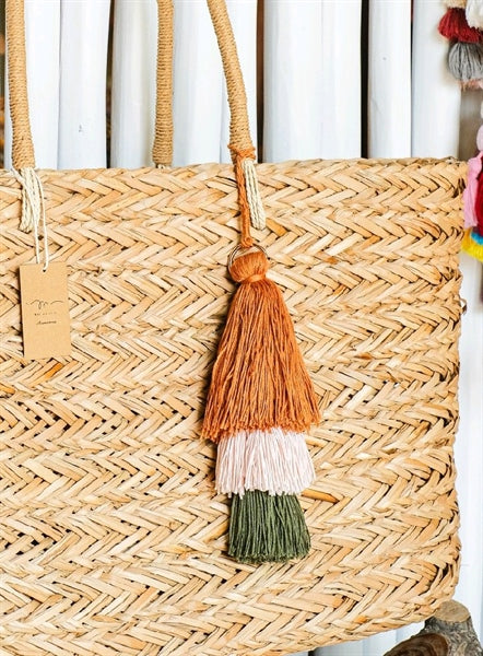 Brown, cream and green tassels on a straw bag.
