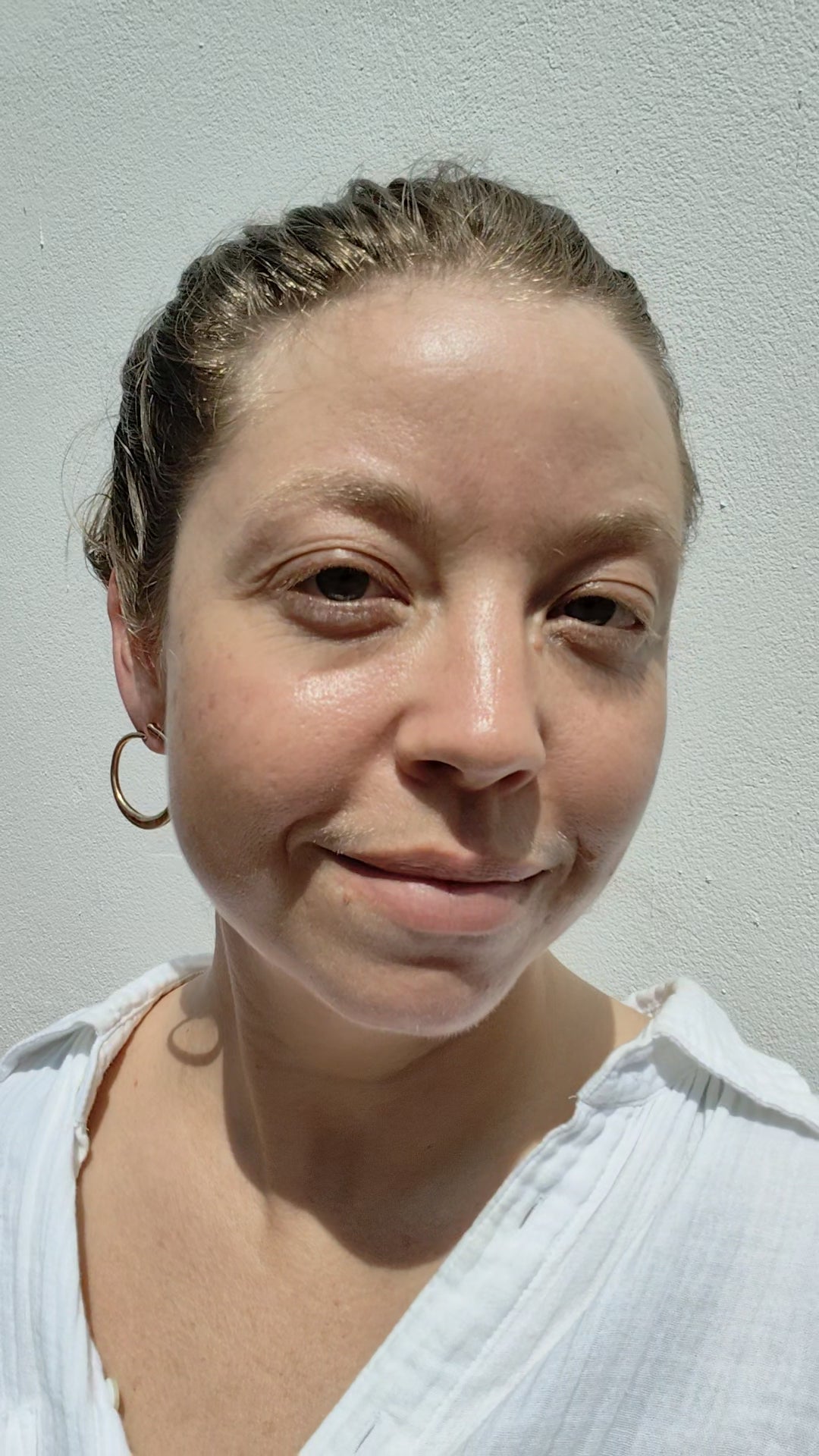 Woman with braided hair wearing a hoop earrings.