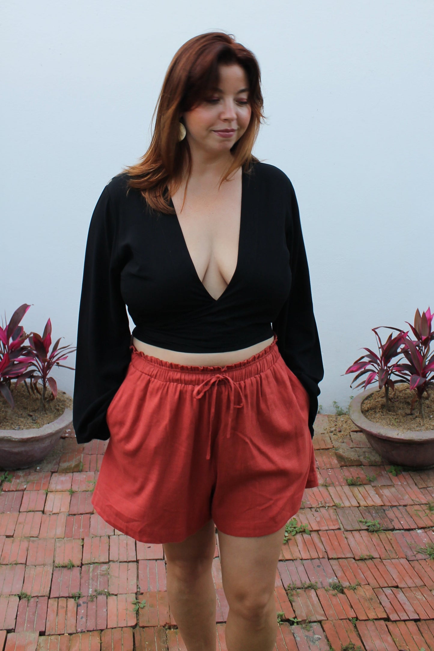 Black crop top with flared sleeves and red shorts.