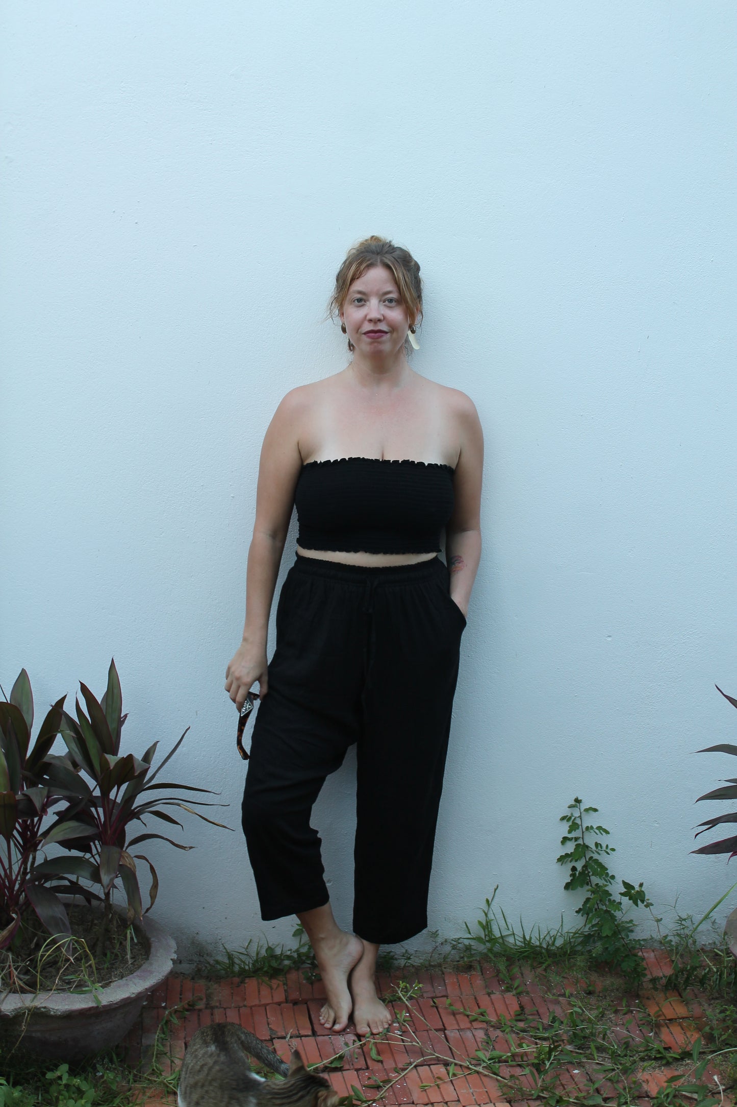 Person wearing black pants and a black tube top.