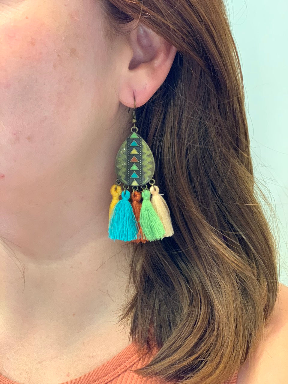 woman wearing boho metal earrings with tassel details.