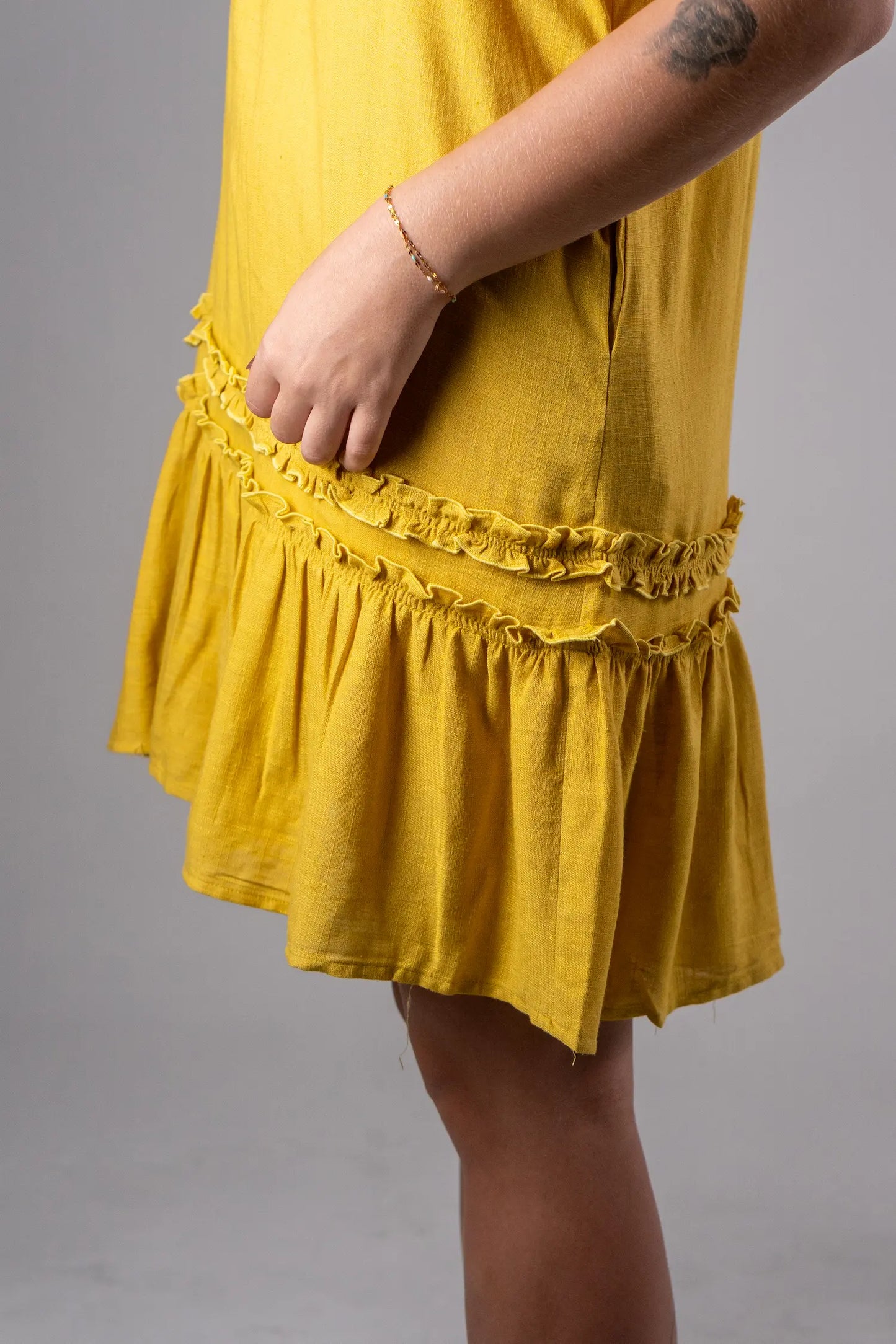 Yellow dress with ruffled hem on a gray background