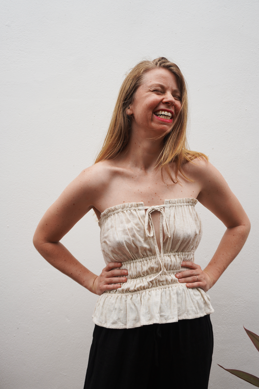 Woman wearing a strapless top with a plain background