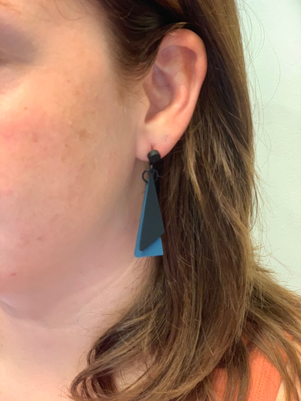 woman wearing boho style blue triangle earrings.