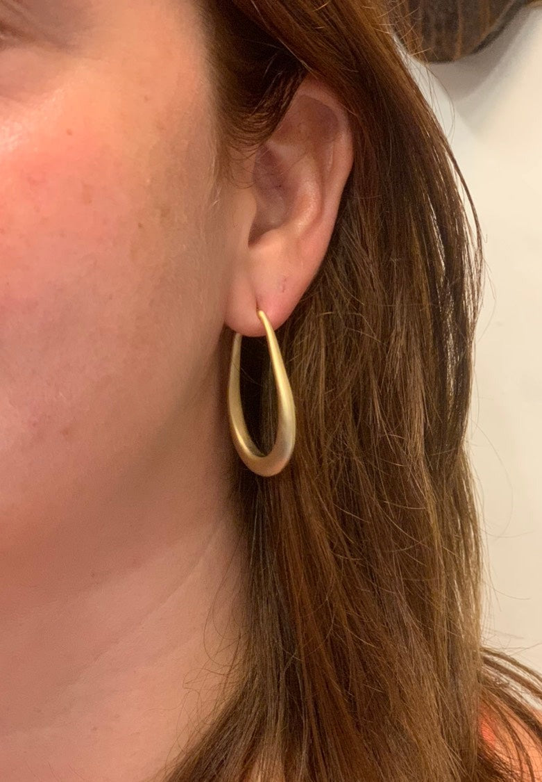 woman wearing boho style gold oval loop earring