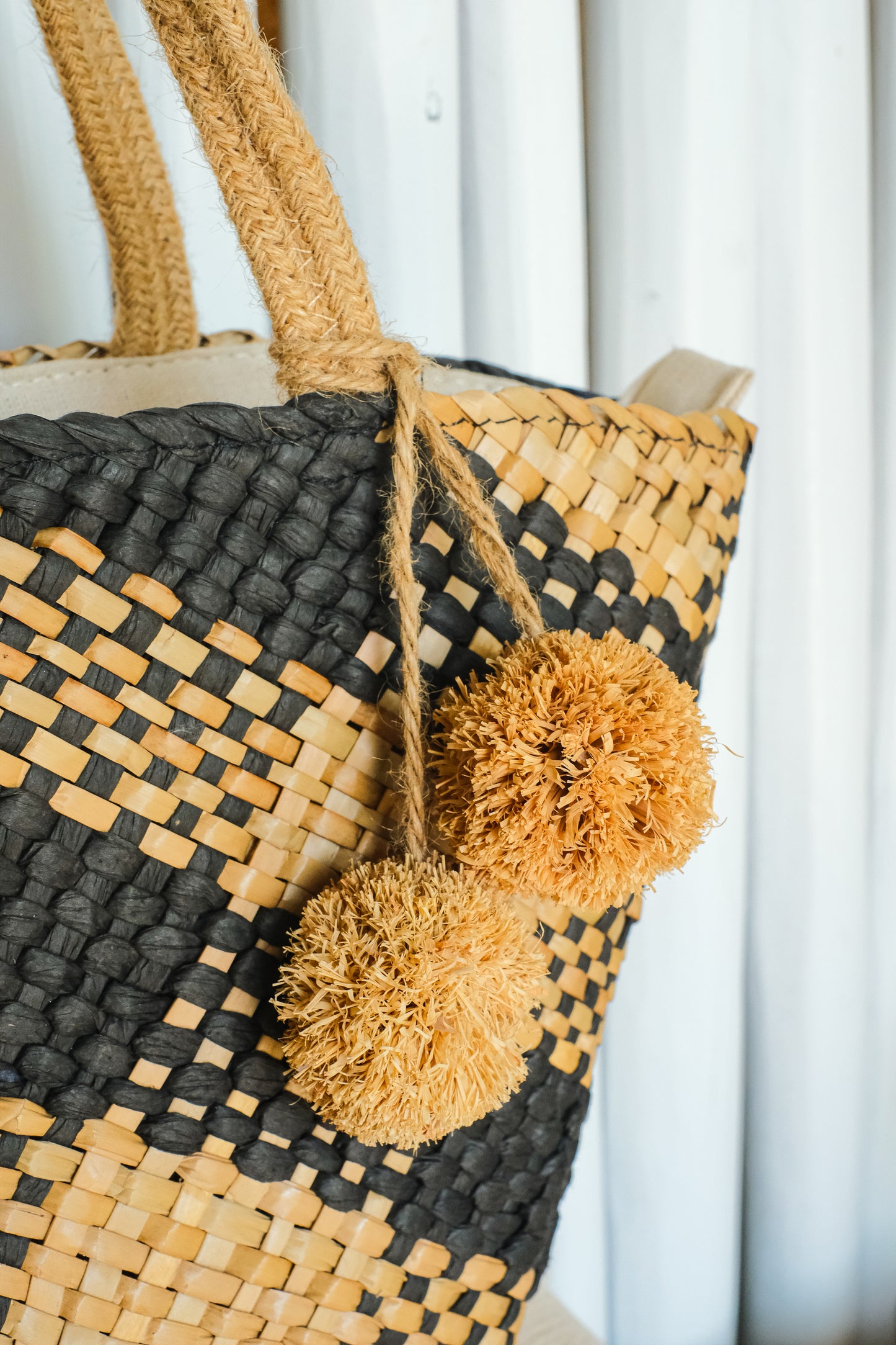 tassels on a boho style handwoven straw handle bag