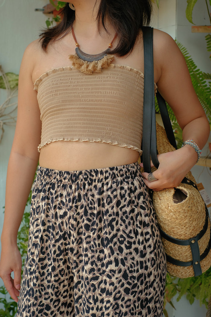 A nude tube top. Leopard print pants.
