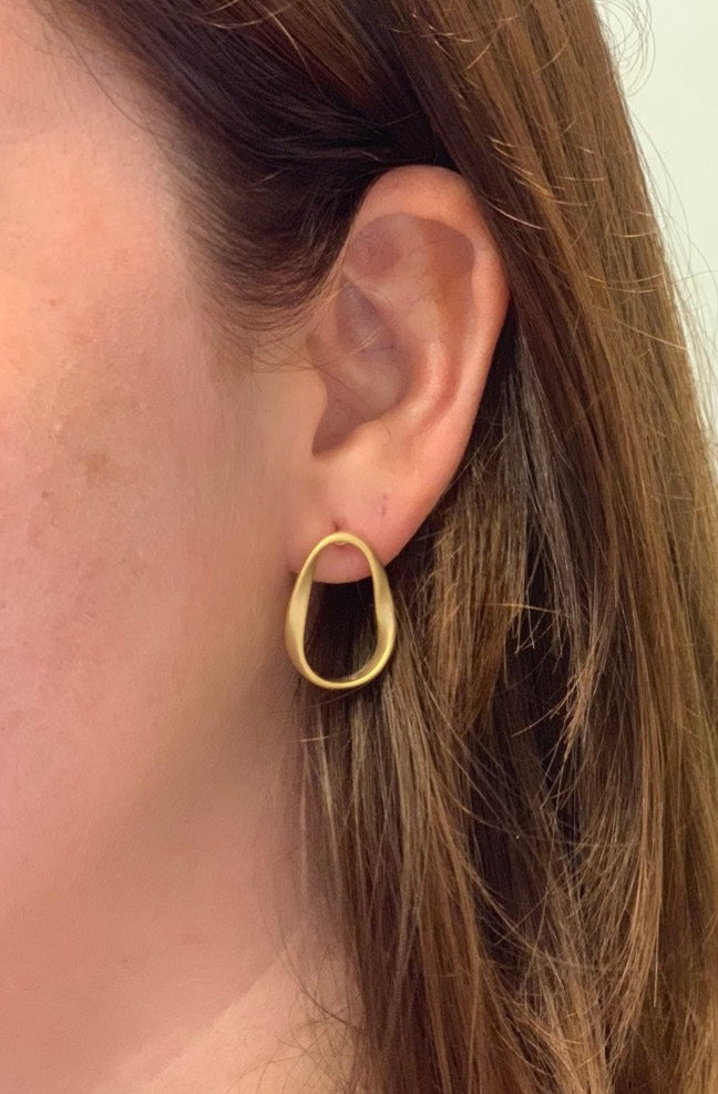 woman wearing boho style oval loop gold earrings