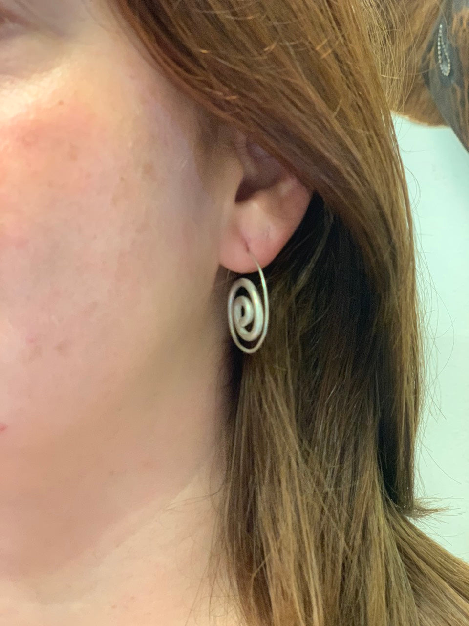 woman wearing boho style spiral silver earings