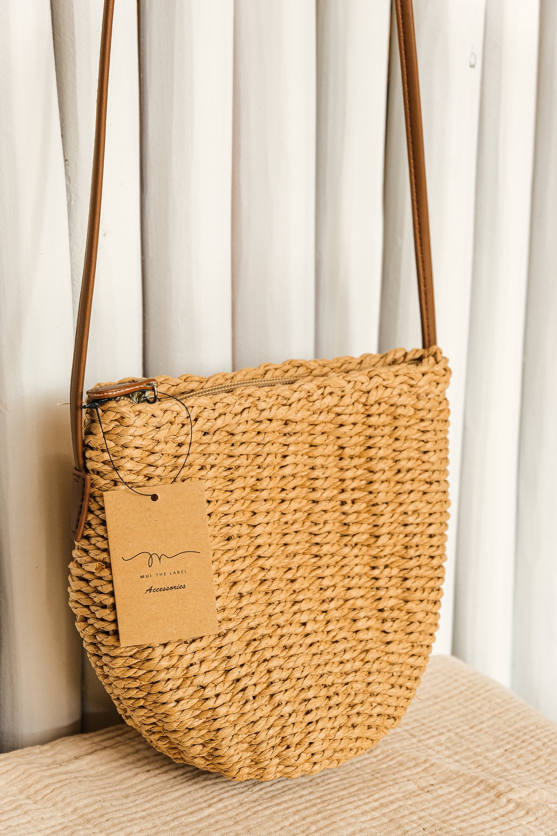 Woven handbag with a visible brand tag on a neutral background