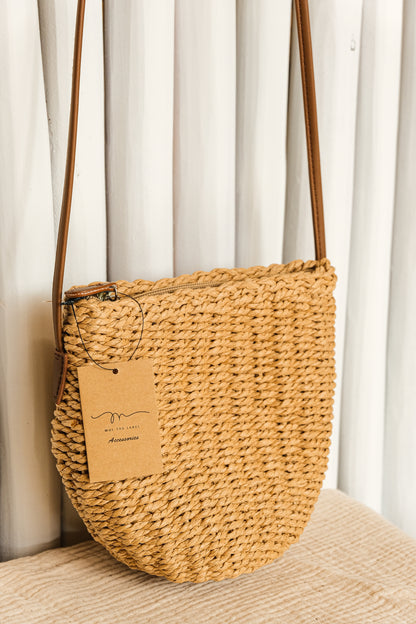 Woven handbag with a visible brand tag on a neutral background