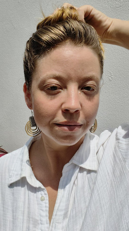 Woman wearing round wooden leopard print earrings. 