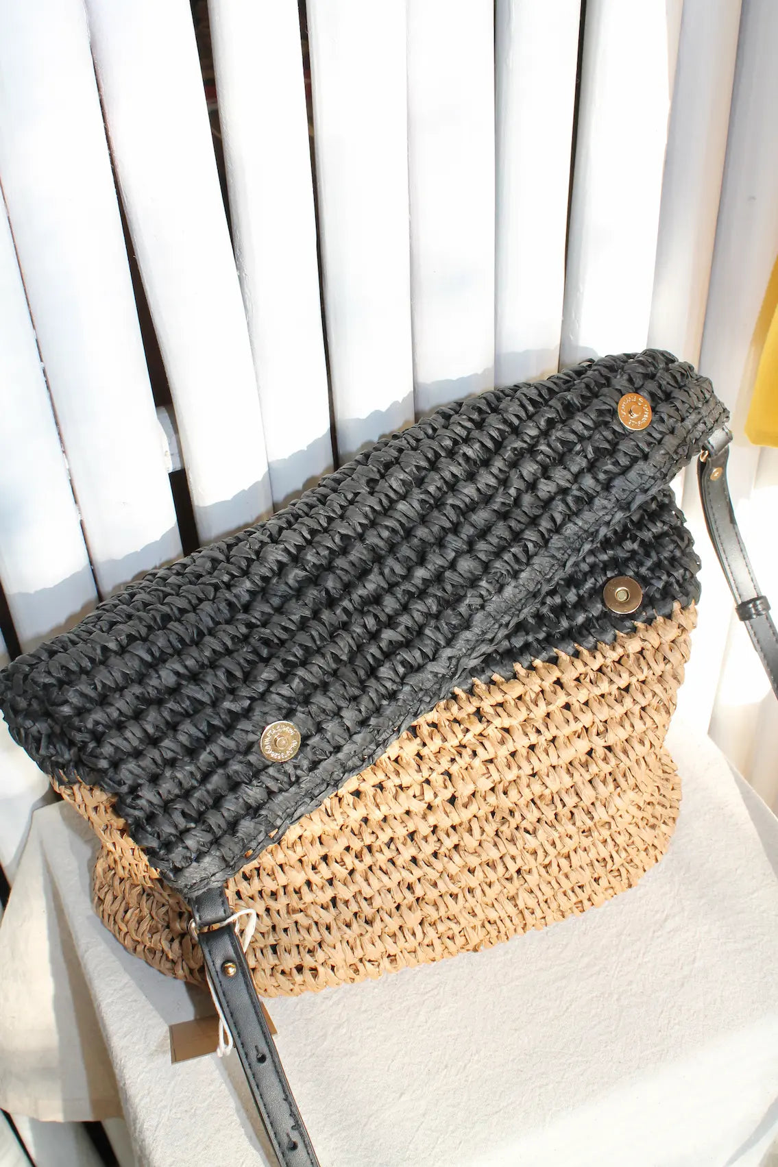 A woven bag with black and cream colors.