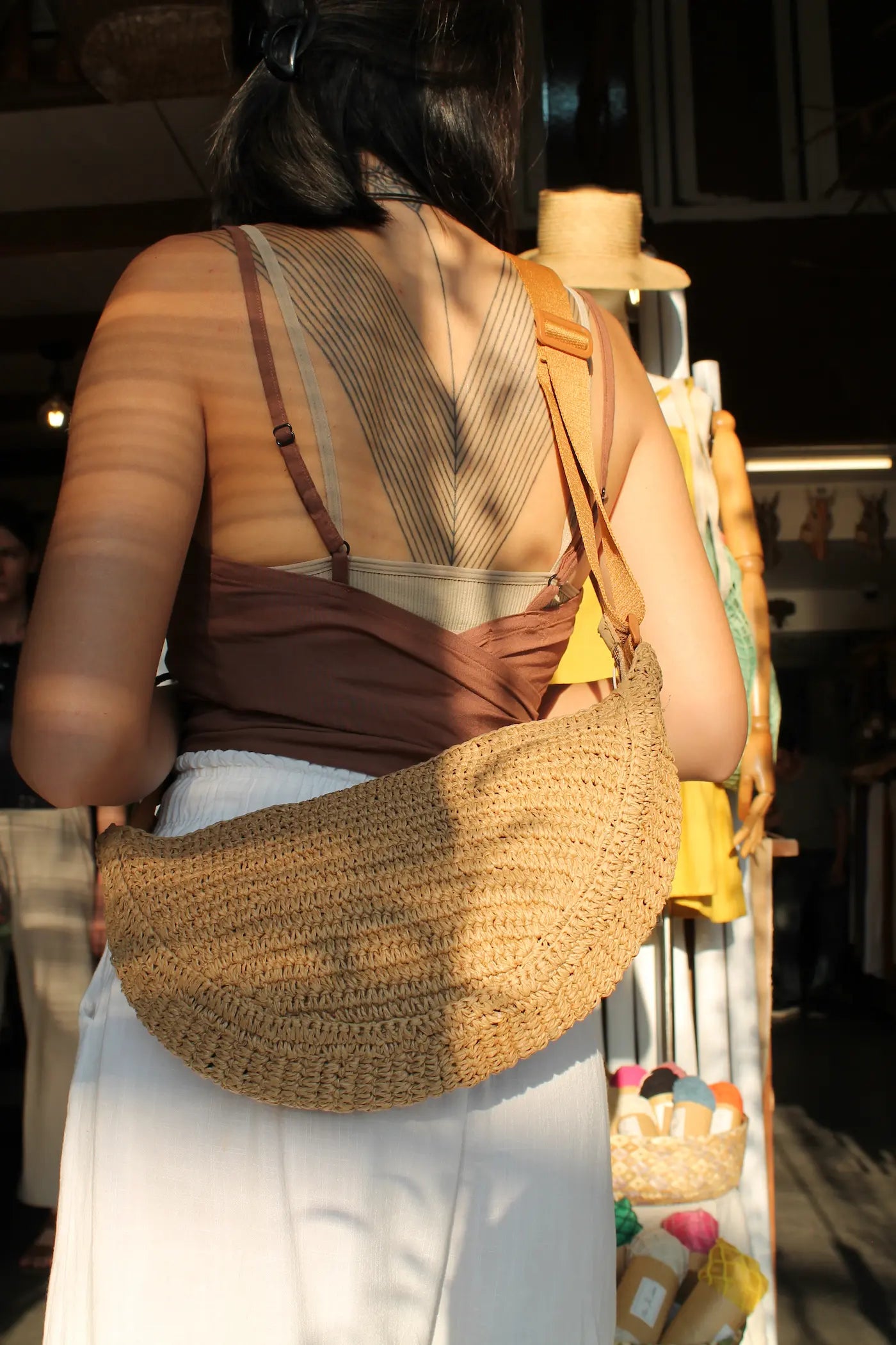 A brown woven sling bag. 