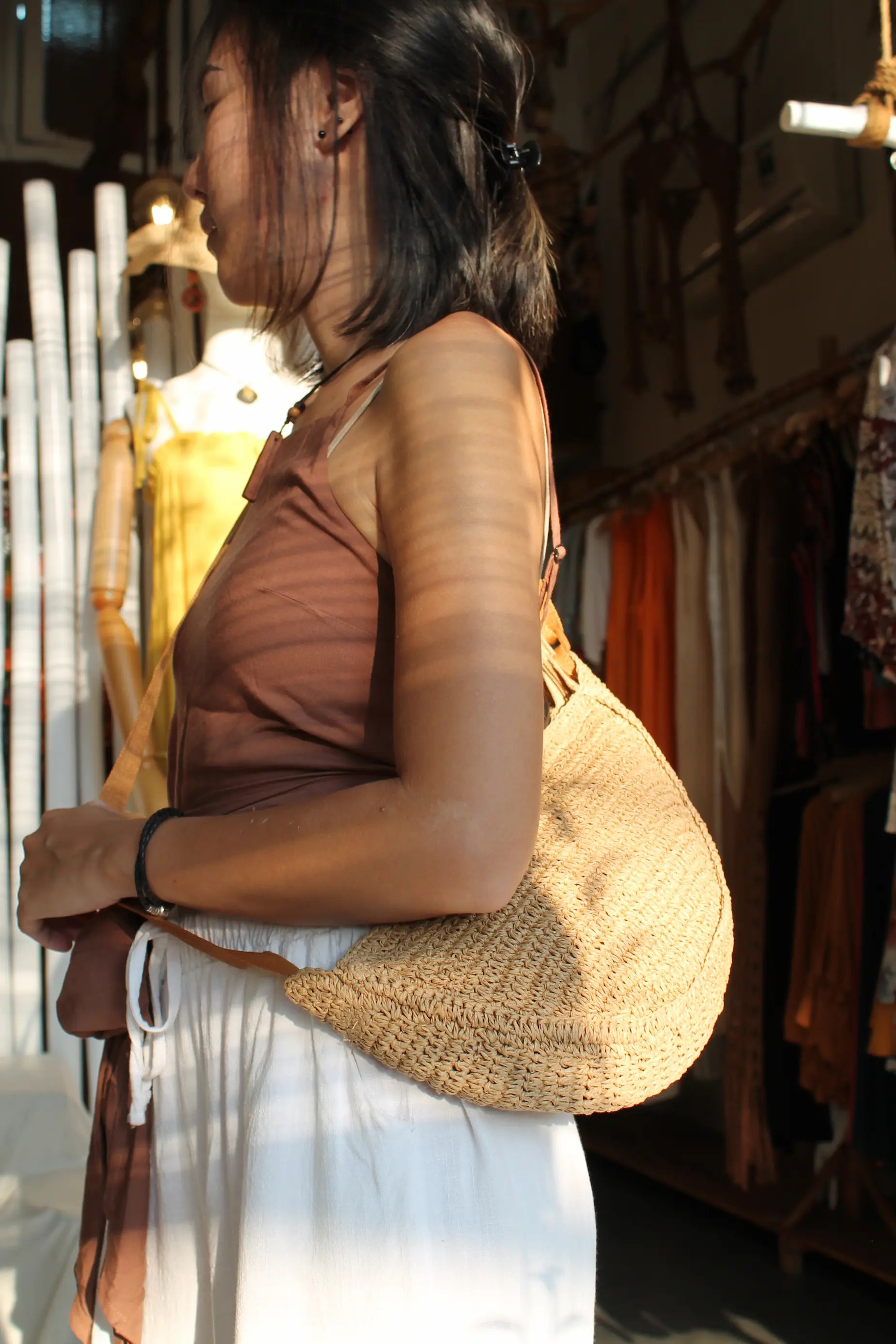 A brown woven sling bag. 