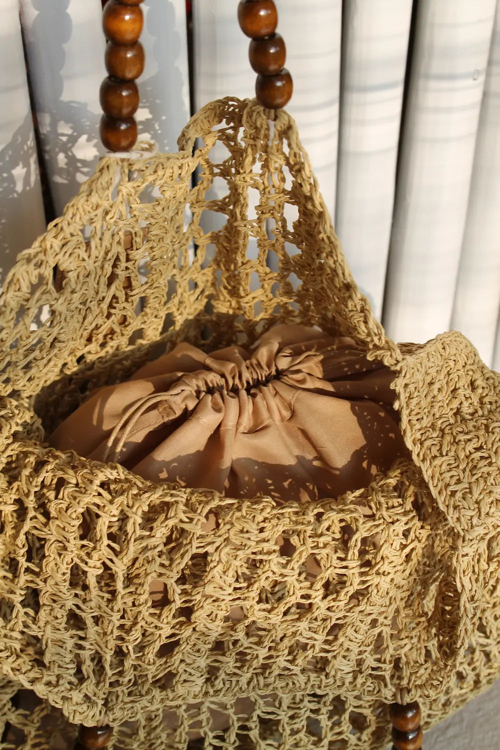 A large woven bag with beaded handles. 