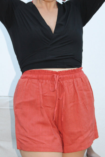 Black crop top with flared sleeves and red shorts. 