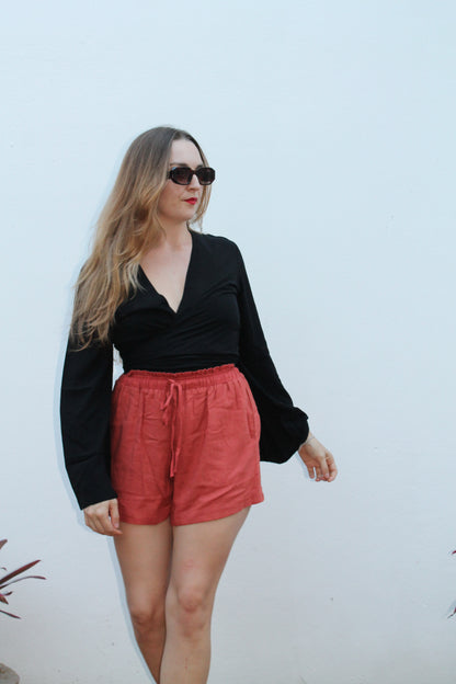 Black crop top with flared sleeves and red shorts. 
