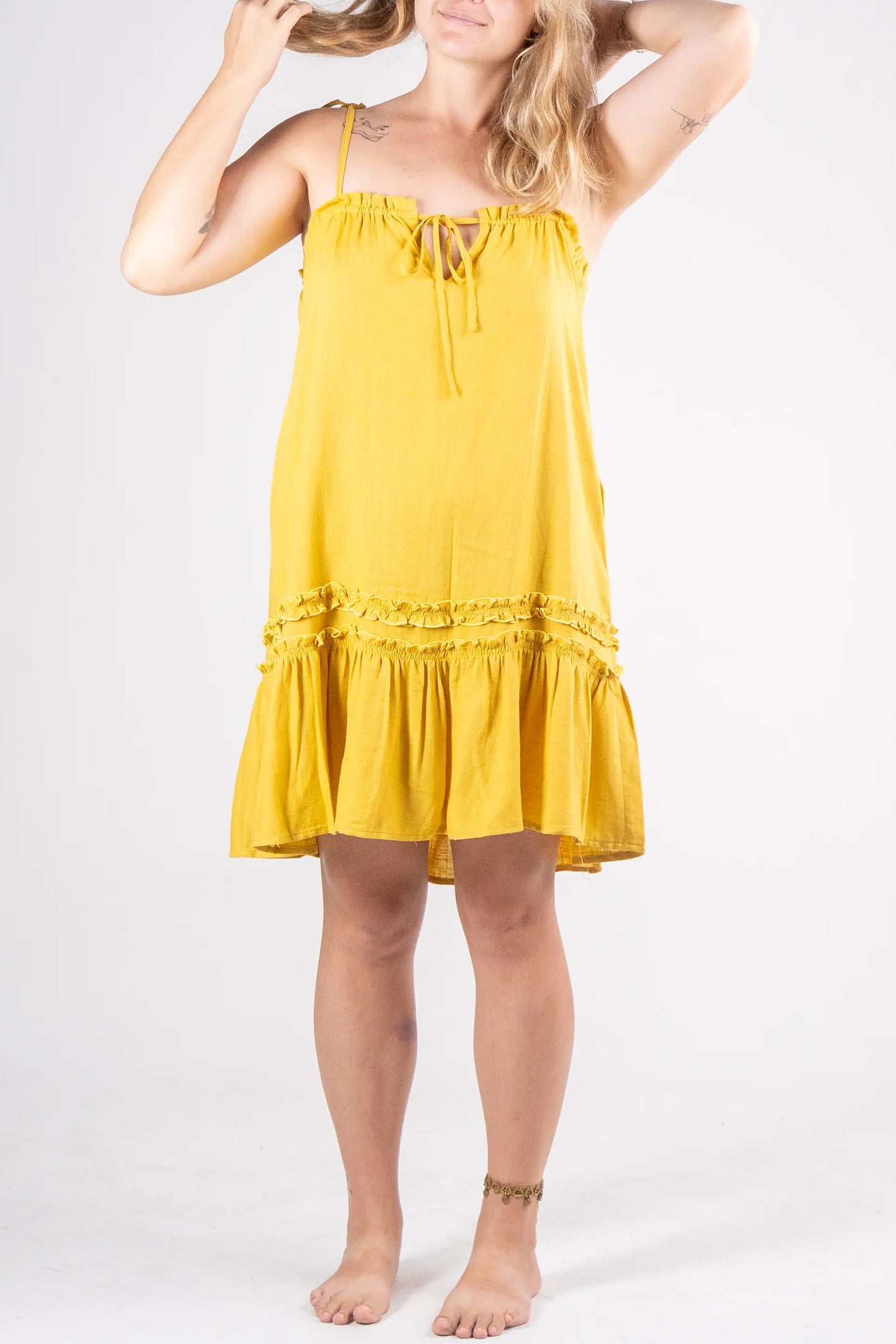 Woman wearing a yellow dress against a white background