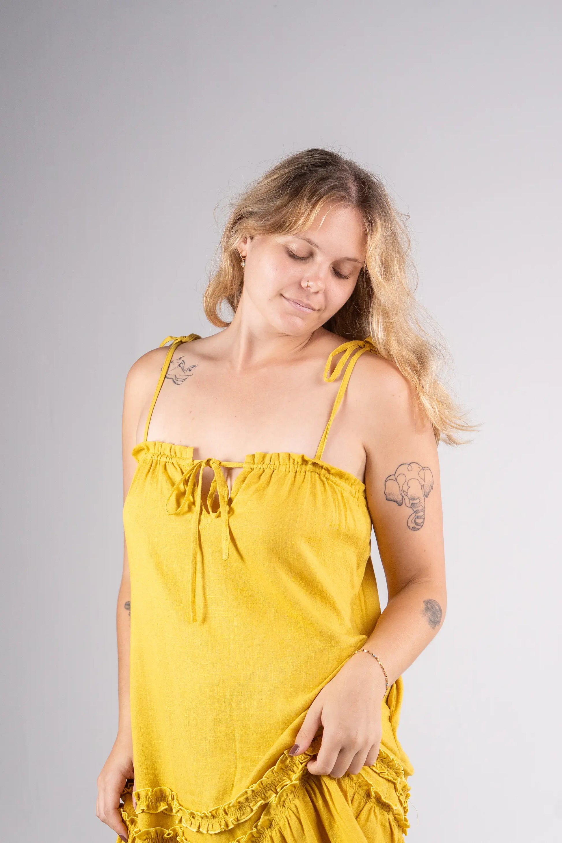 Woman wearing a yellow dress against a gray background