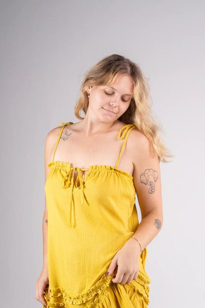 Woman wearing a yellow dress against a gray background