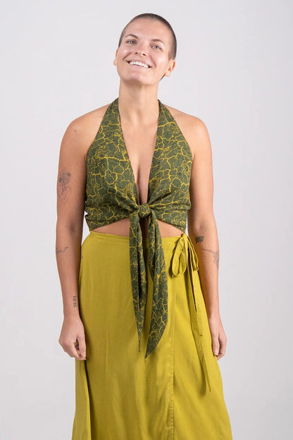 Woman wearing a green patterned top and yellow skirt on a white background