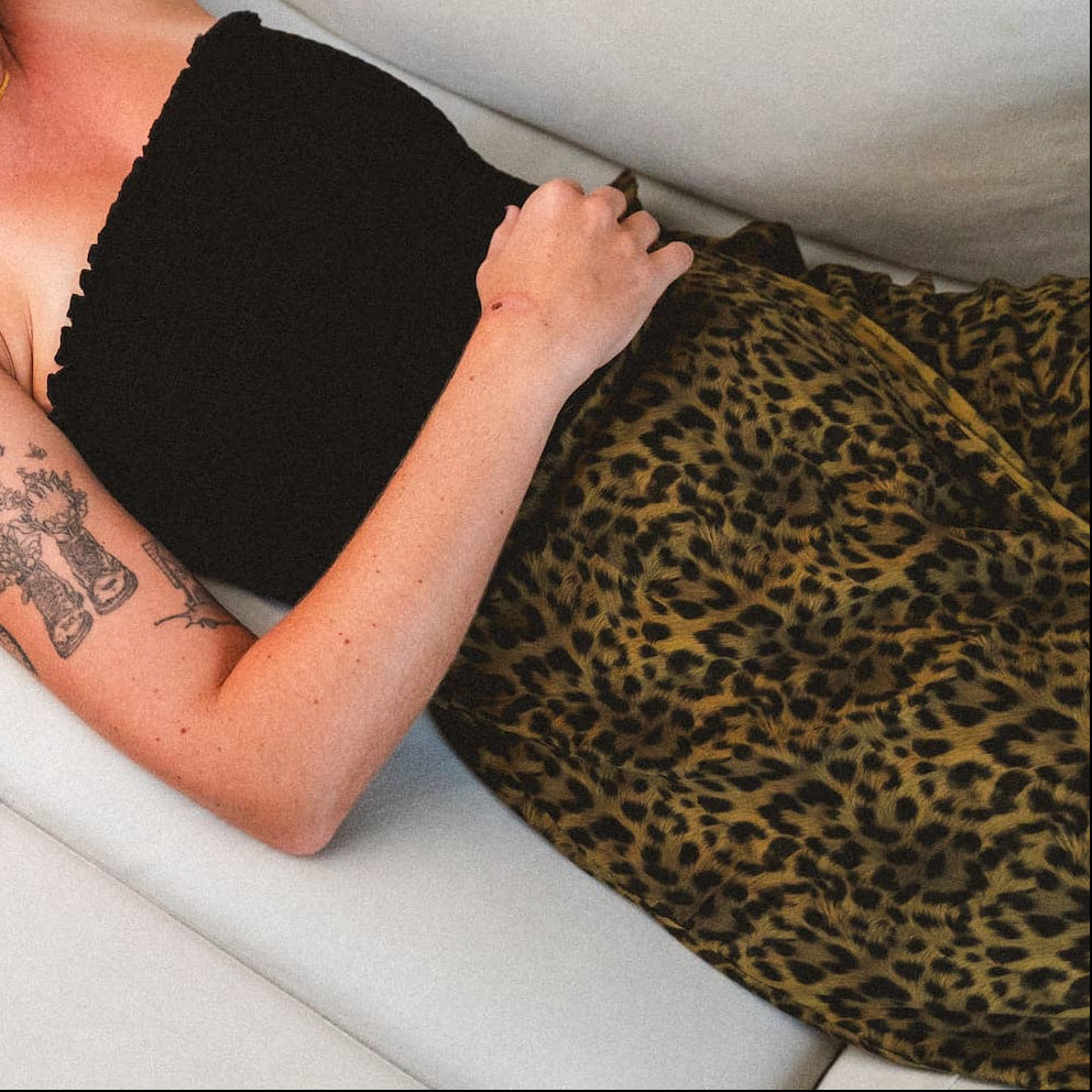 Person wearing a cheetah print skirt and black tube top. 