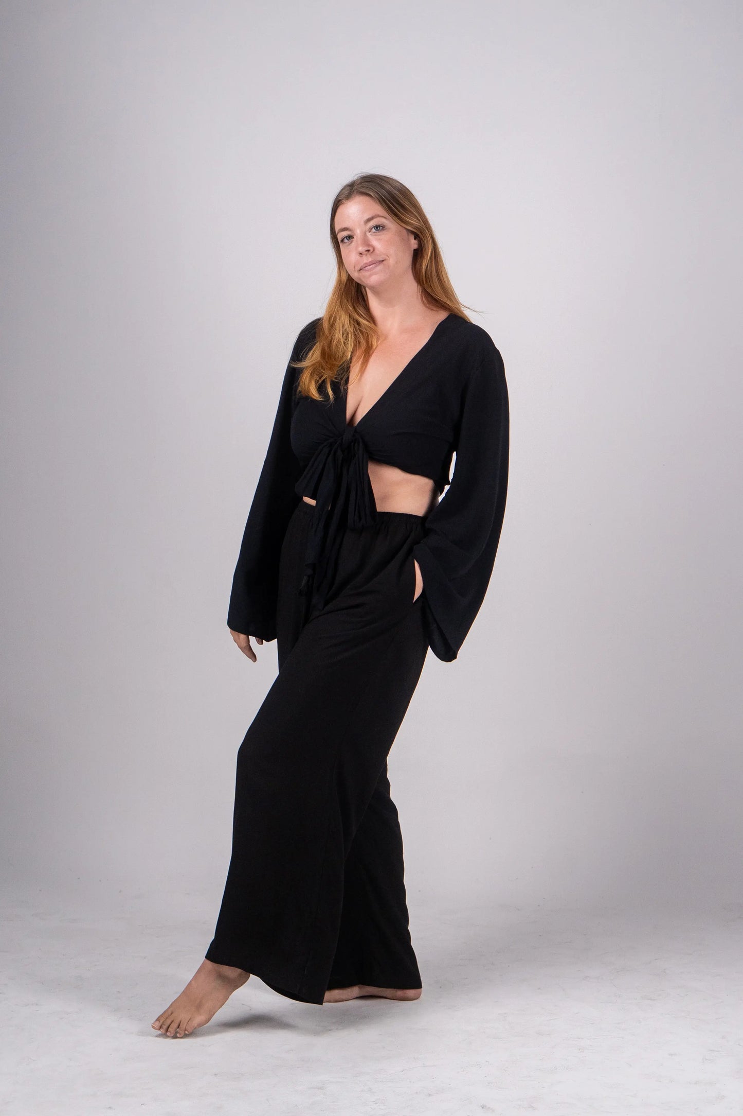 Woman wearing a black outfit on a plain background