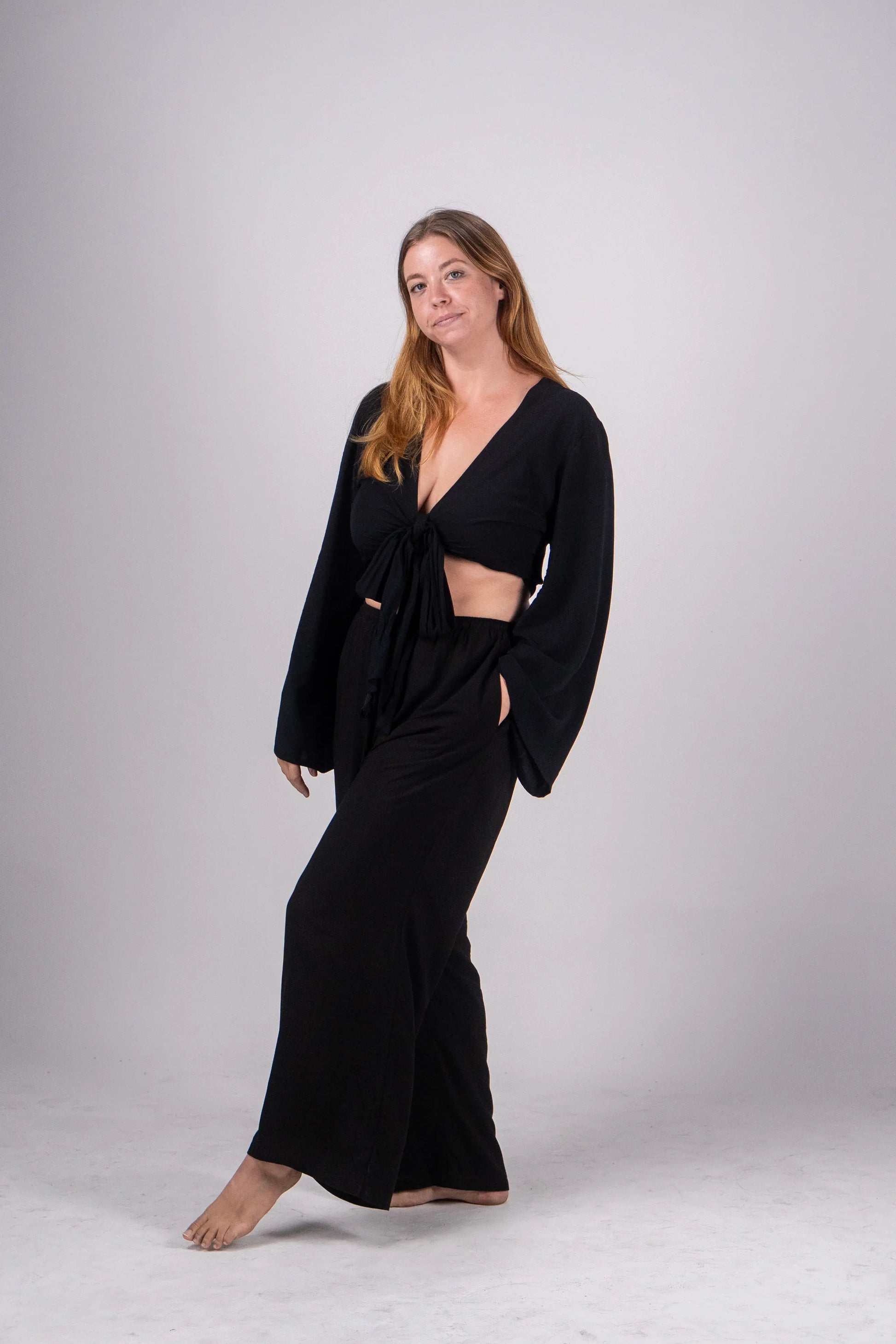 Woman wearing a black outfit on a plain background