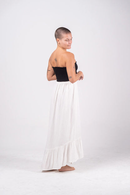 Woman wearing a black strapless top and white ruffled skirt on a white background