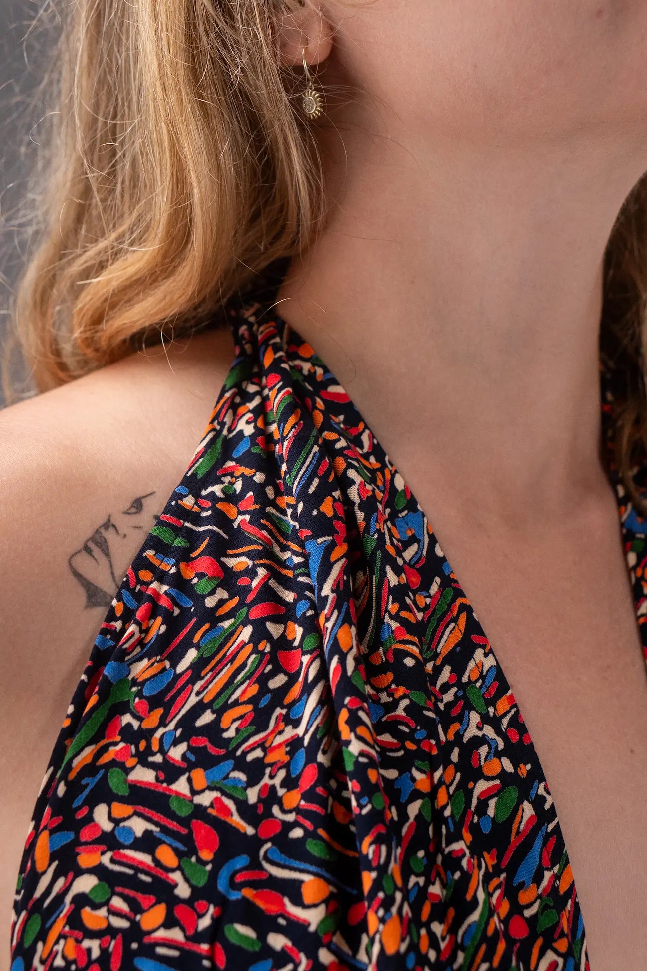 Close-up of a colorful patterned top worn by a person with a neutral background