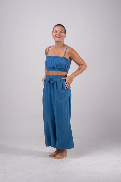Woman wearing a blue outfit standing against a plain background