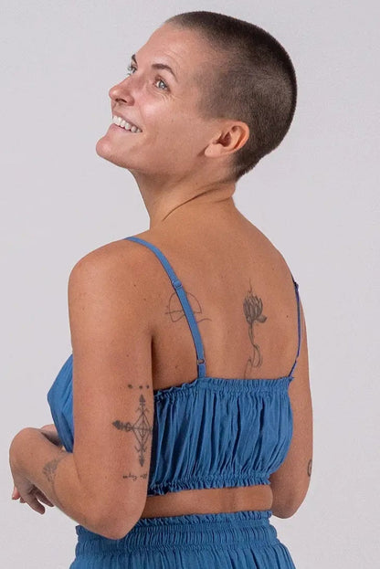 Woman wearing a blue matching set on a plain background