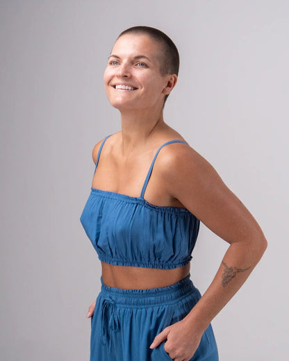 Woman wearing a blue outfit against a gray background