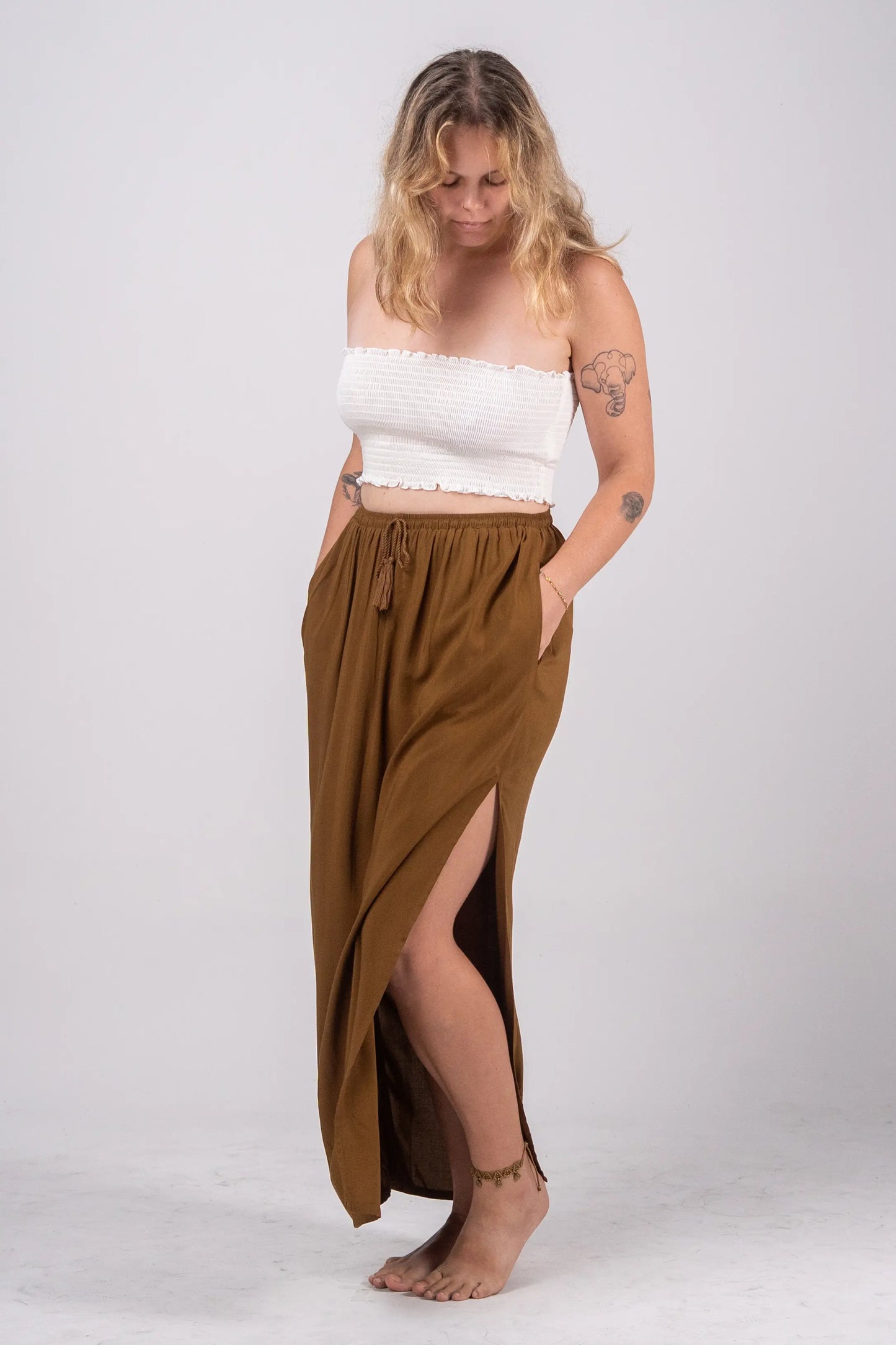 Woman wearing a white top and brown skirt on a white background