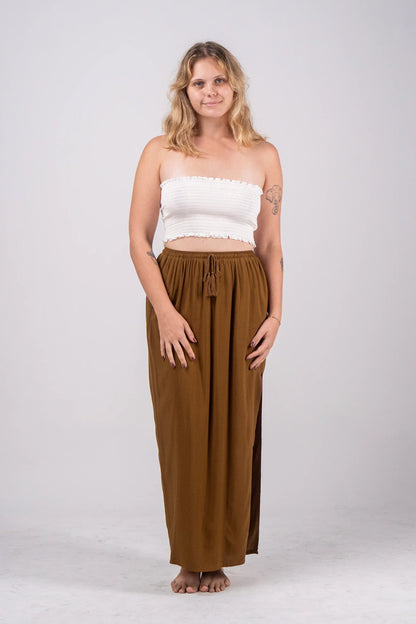 Woman wearing a white top and brown pants on a white background