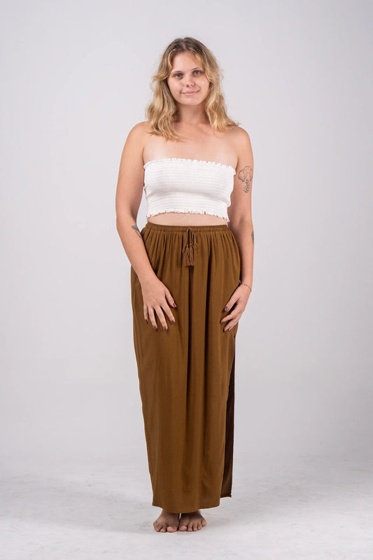 Woman wearing a white top and brown pants on a white background