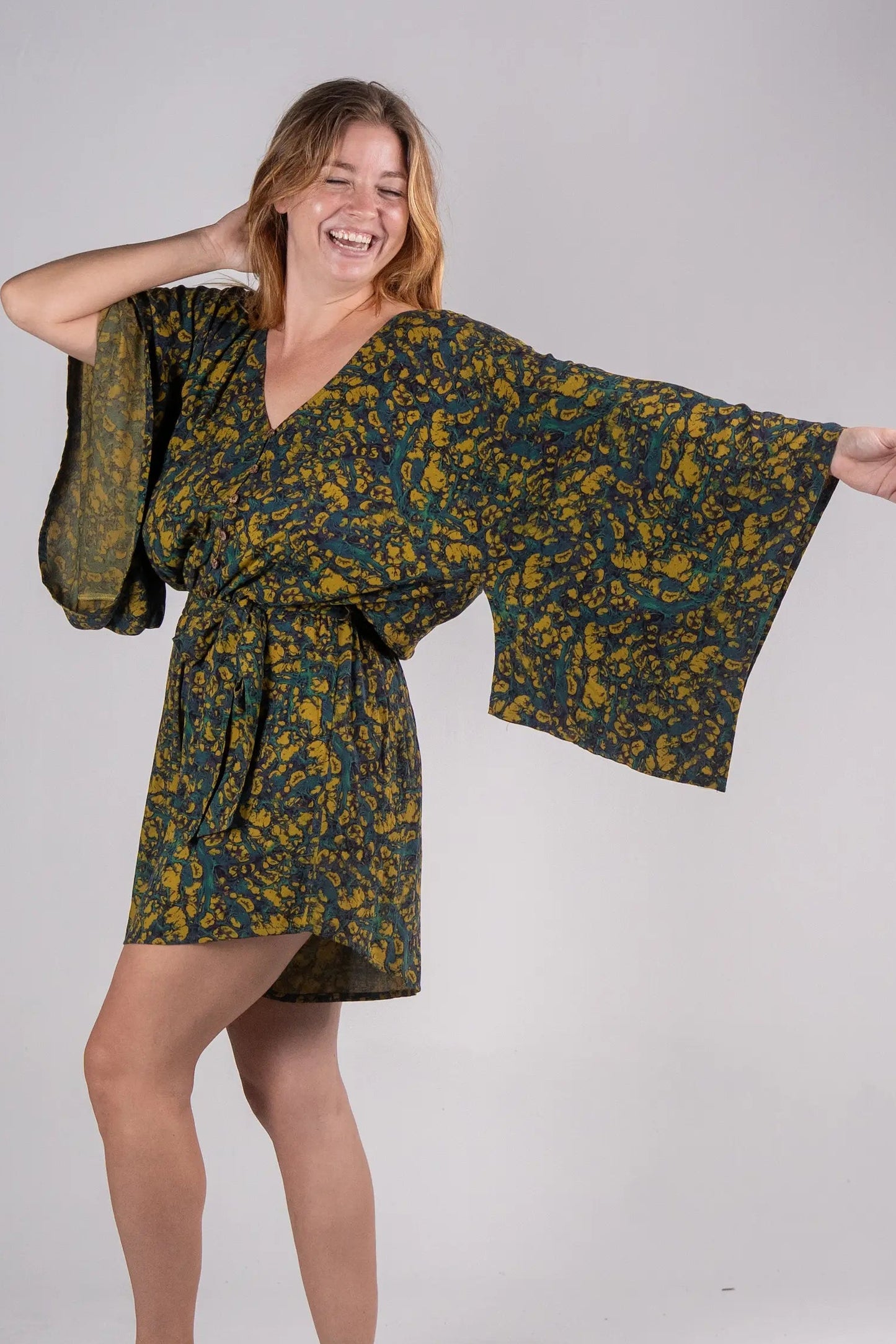 Woman wearing a floral kimono-style dress on a plain background