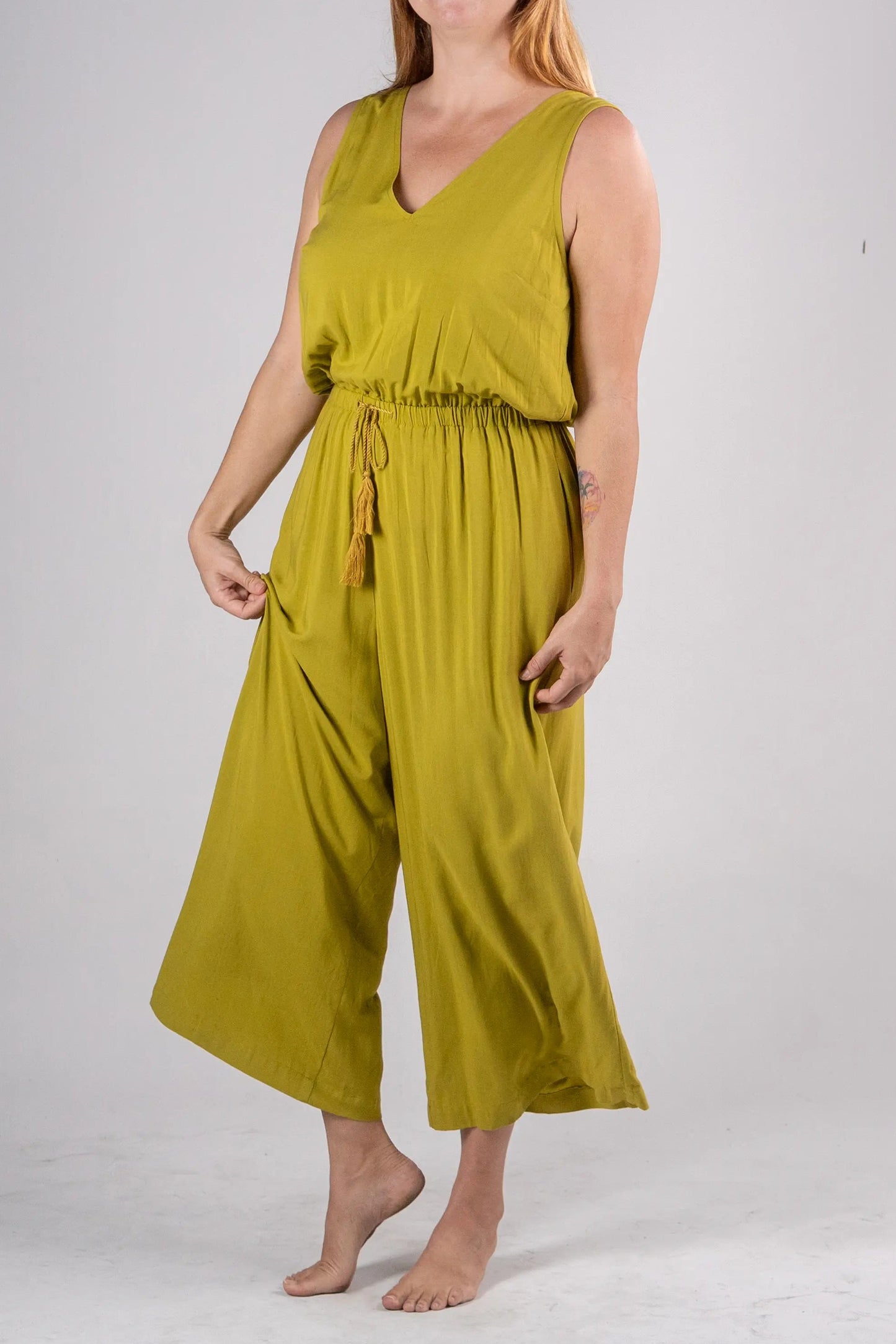 Woman wearing a green jumpsuit on a white background