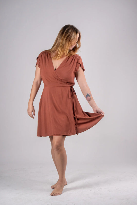 Woman wearing a rust-colored dress on a plain background