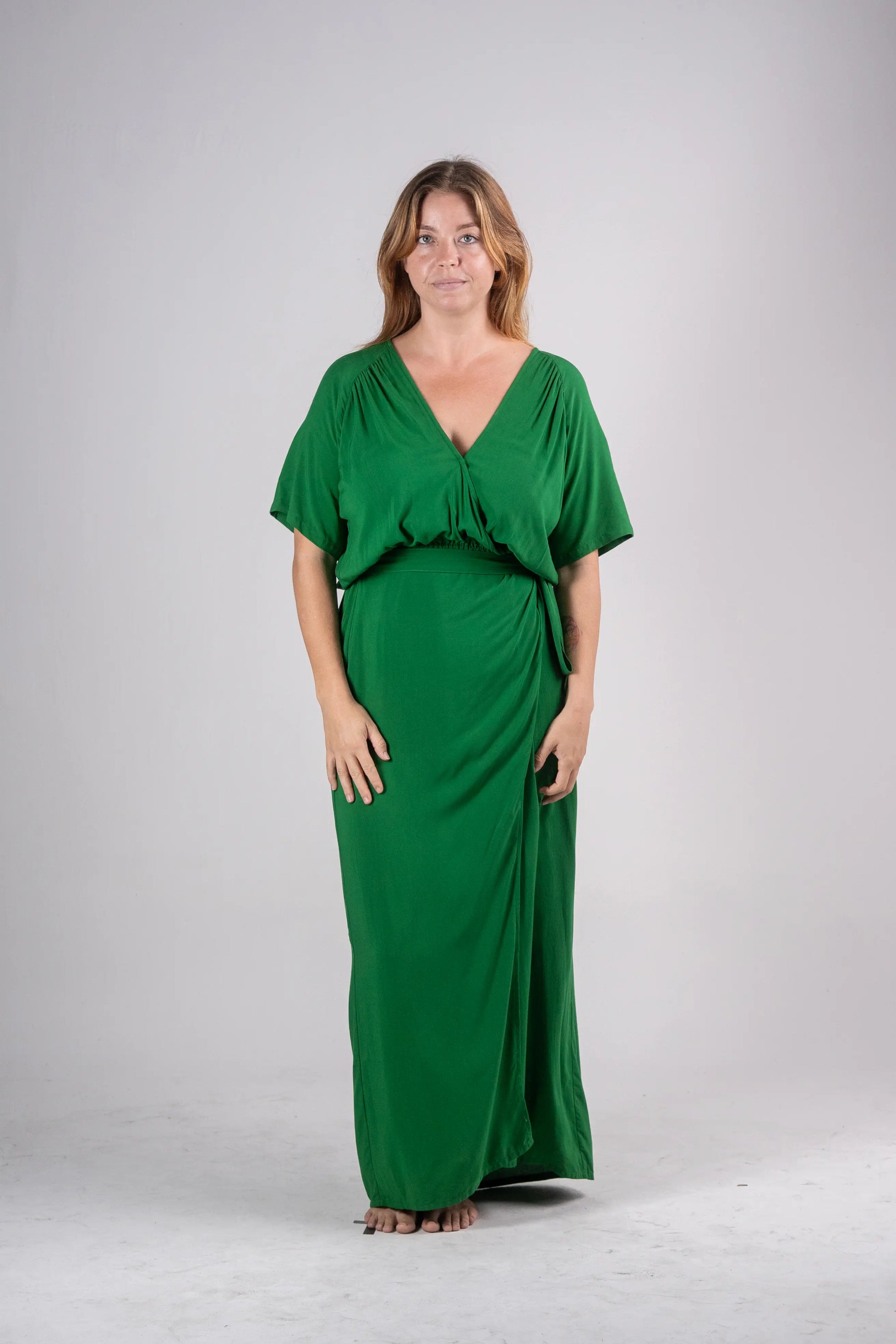 Woman wearing a green dress against a plain background