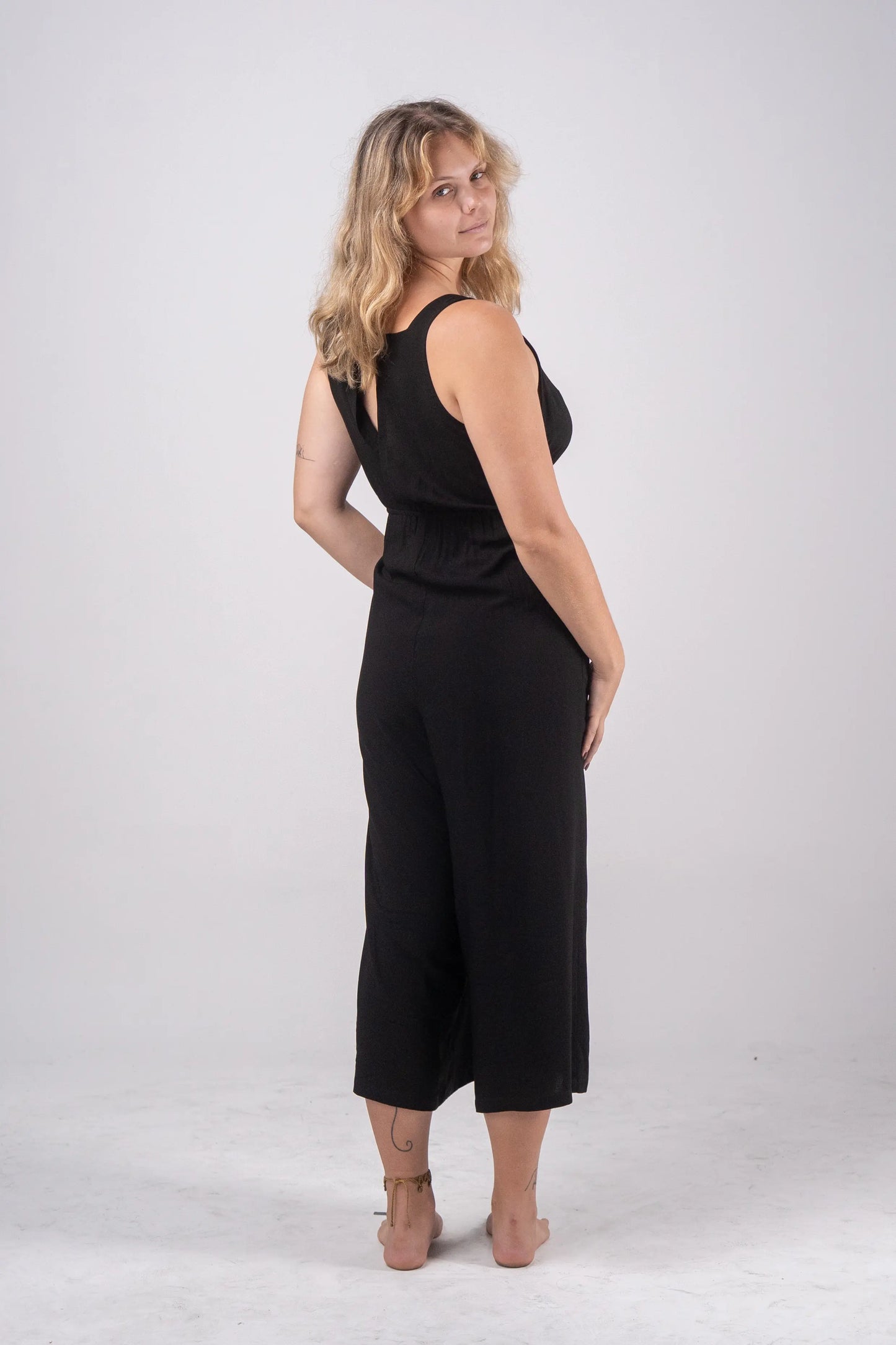 Woman wearing a black jumpsuit on a white background