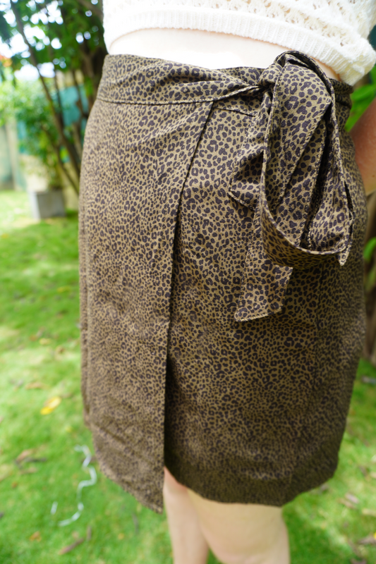 Leopard print wrap skirt worn by a person outdoors on a grassy area