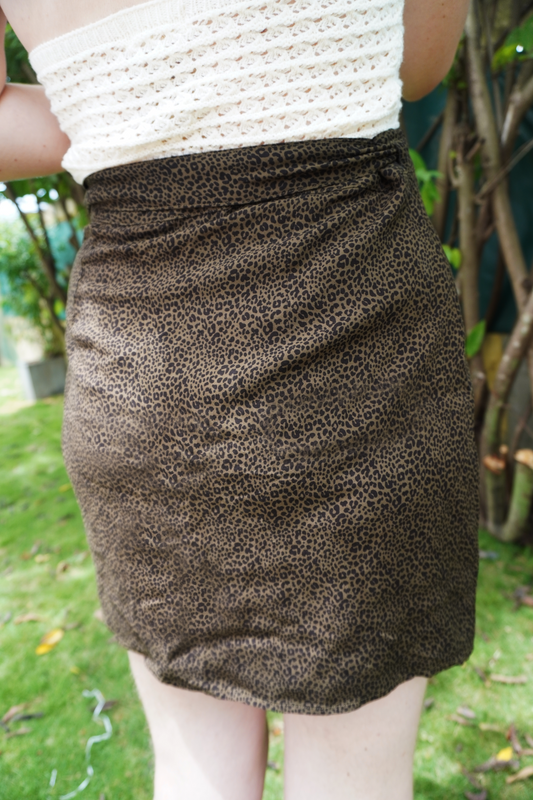 Brown leopard print skirt worn by a person outdoors on a grassy area