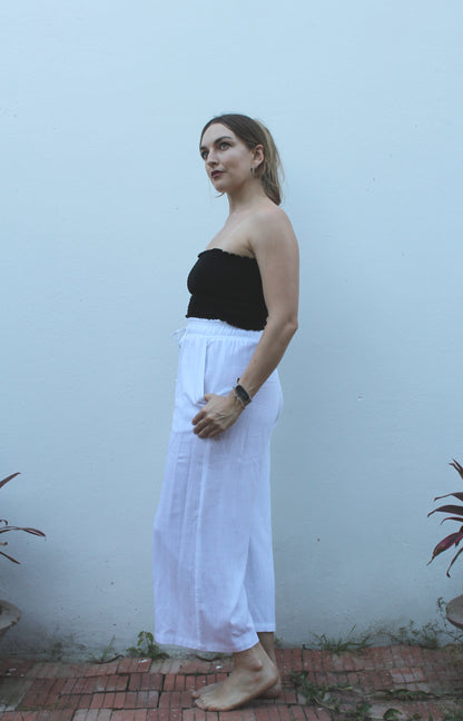 A black top and white pants. 