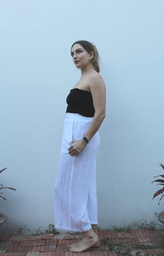 A black top and white pants. 