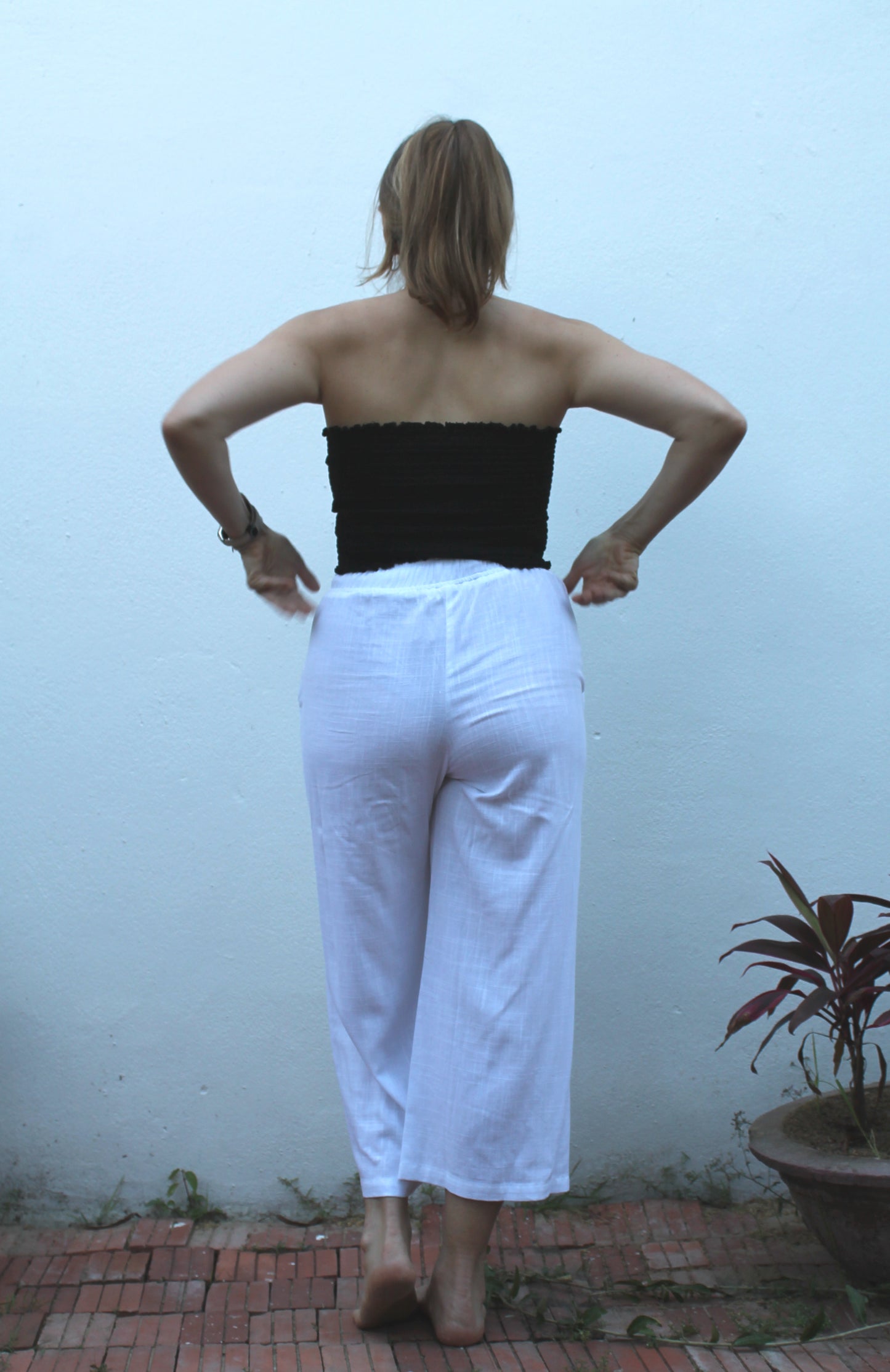 A black top and white pants. 