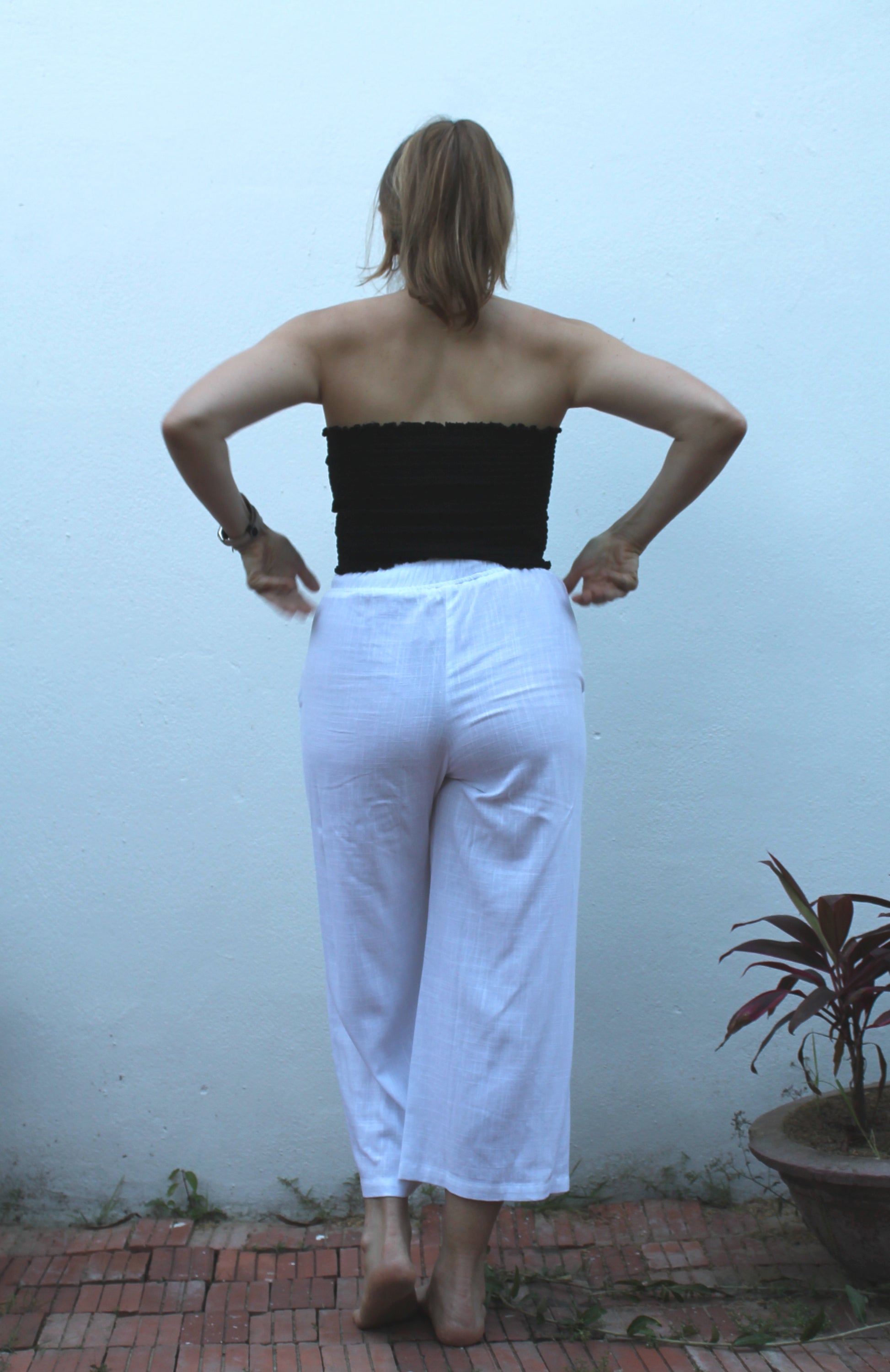 A black top and white pants. 