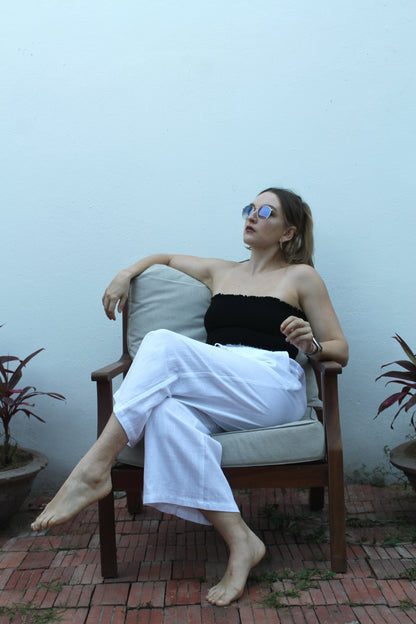 A black top and white pants. 